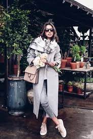 modern outfit with scarf longjacket and jeans posing outdoors, representing style tips for women